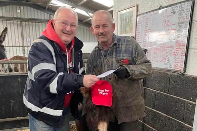 Steve Warmsley with Kye the donkey and John Nuttall at the cheque presentation.
