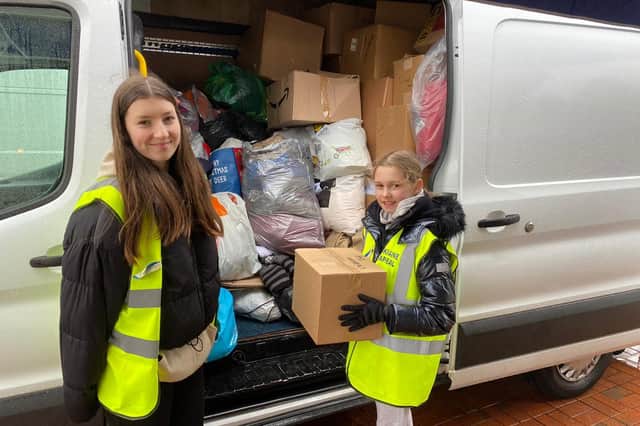 Freya Lyons, 14, and Belle Nicholls, 10, filliing a van with donations at the appeal at the  Seafood Cafe in Skegness.