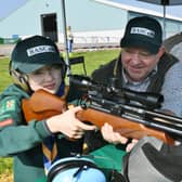 Kids Country Cubs and Scouts event at the East of England Arena. Instructor Ian Richardson with Joshua Perkins learning how to use and air rifle. EMN-220328-140200009
