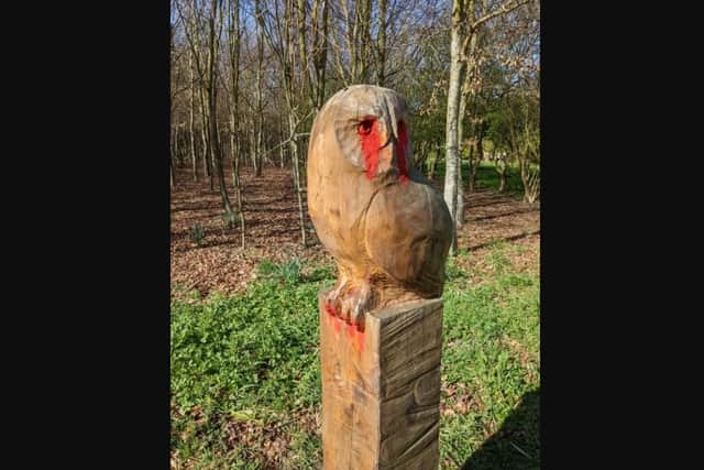 Vandals left red paint on wood carvings at Beech Wood.