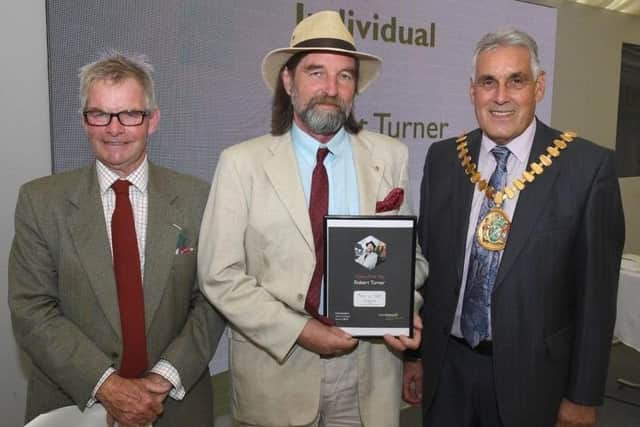 Leader of LCC Martin Hill (left) and chairman of LCC Tony Bridges (right) present the 2019 Citizen of the Year award to  Robert Turner, of Caistor, a Lions Club member for more than 30 years.