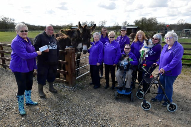 Members of the 50+ Fitness group from Mablethorpe present a cheque to Radcliffe Donkey Sanctuary volunteer Ross Ckarke.