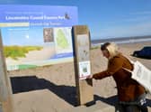 Chelsey Everatt -,  producer of Audio Tails, demonstrates how to use the barcodes on the beach at Huttoft, which is one of 24 locations around East Lindsey.