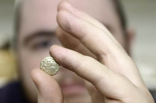 The auction room's David Phillips examines the 2,000 year old gold quarter stater found at Swinhope EMN-220419-151632001