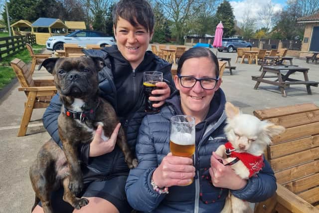 Cheers everyone - Lisa Garrad and Lorna Smith of Skegness, accompanied by their dogs Timmy and Teddybear, enjoying a first drink in months at the Welcome Inn.
