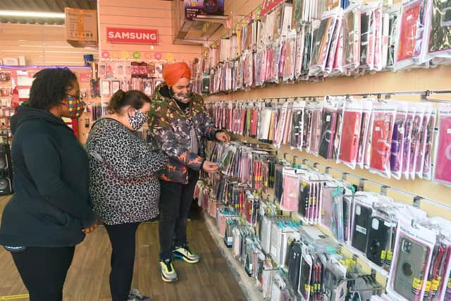 Visitors checking out the mobile phone shop on the outdoor market at Fantasy Island in Ingoldmells.