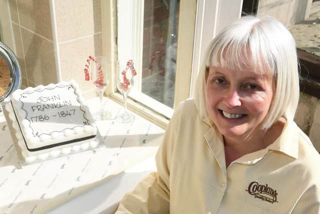 Cooplands manager Cheryl Manning with the cake baked to celebrate the birthday of local explorer Sir John Franklin.