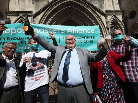 Tom Hedges celebrating with  a bottle of Prosecco outside the Royal Courts of Justice in London.