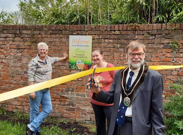 Coun Stephen Bunney cuts the ribbon to officially open the kitchen garden, watched by Cathy Sirrett, left, and Nicky Brooksbank EMN-210518-102144001