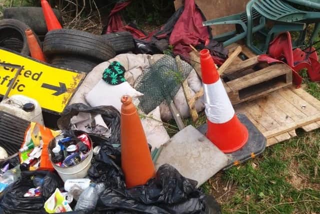 Rubbish dumped in the Ancaster Valley, mixed up with traffic cones and a diversion sign. EMN-210514-185527001