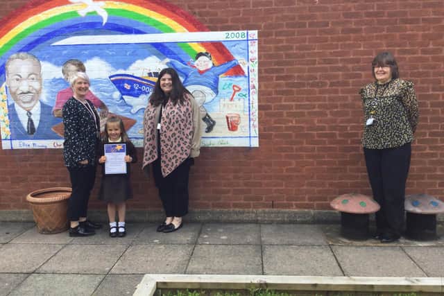 EYFS staff Megan Tory and Leah Dowling with headteacher Mrs Caroline Wellsted and Lily with her certificate.