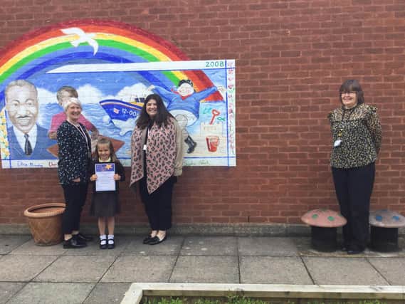 EYFS staff Megan Tory and Leah Dowling with headteacher Mrs Caroline Wellsted and Lily with her certificate.