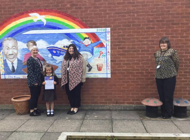 EYFS staff Megan Tory and Leah Dowling with headteacher Mrs Caroline Wellsted and Lily with her certificate.