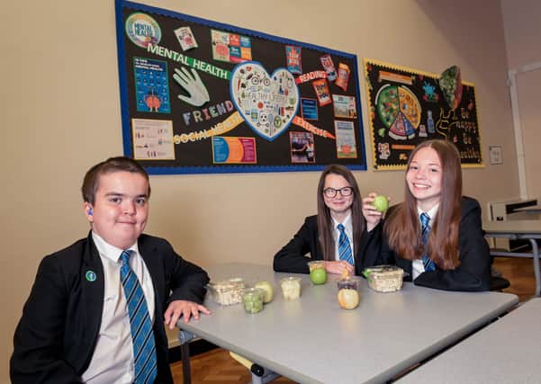 Lennon Dovey, Paige Harriman and Jess Hopps (all 14 years old) choose fruit at break time as the academy promotes good health and mental wellbeing