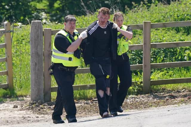 A man is detained at Hallington House Farm, on the outskirts of Louth, Lincolnshire, by officers hunting for Daniel Boulton.Picture: PA Wire