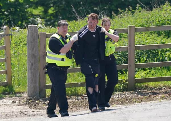 A man is detained at Hallington House Farm, on the outskirts of Louth, Lincolnshire, by officers hunting for Daniel Boulton.Picture: PA Wire