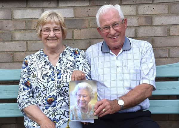 Betty and Geoff Ward with their card from The Queen.
Photo by John Edwards
