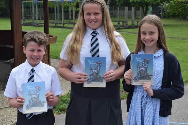 Pupils with their copy of Seven Knights. EMN-210617-132104001