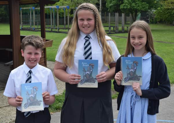 Pupils with their copy of Seven Knights. EMN-210617-132104001