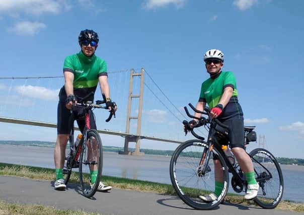 Nigel Johnson and Dean Marratty reach the Humber Bridge on their triathlon challenge. EMN-210625-173432001