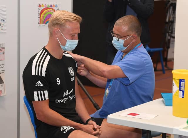 Jonathan Van-Tam vaccinating Jordan Burrow of Boston United