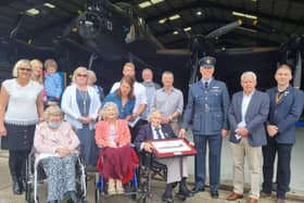 Fred Pearce (centre) celebrating his 100th birthday in the shadow of the Lancaster with 207 Squadron Wing Commander Scott Williams (right) , of RAF Marham, family and friends.