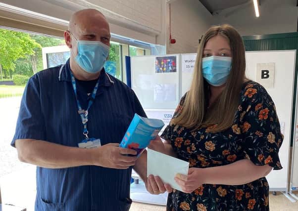 Terry Vine (left ), Clinical and Operational Lead for the Lincolnshire Showground Mass Vaccination Centre, presents chocolates to the recipient of the 100,000th vaccination. EMN-210628-144308001
