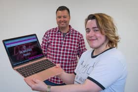 Charity founder Damien Reynolds (back) and employee Alex Inkley (front) with a Wolfpack project laptop