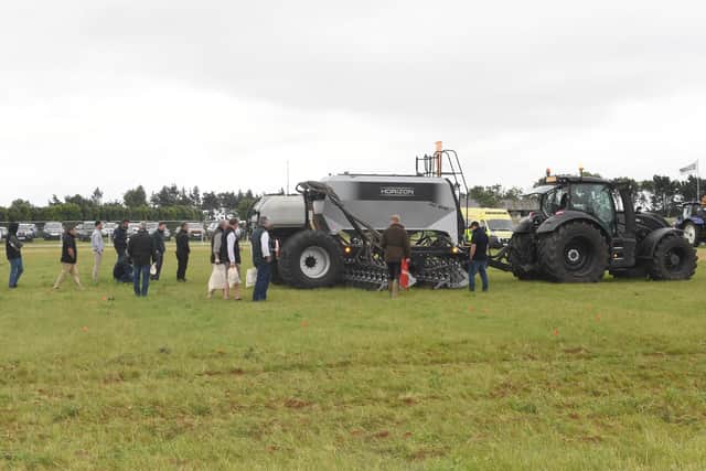 Farmers closely inspect the effectiveness of a new piece of kit being demonstrated at Cereals 2021. EMN-210107-112558001