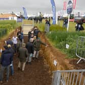 Visitors to Cereals 2021 inspect the 'soil pit' displaying the root systems of crops. EMN-210107-112857001