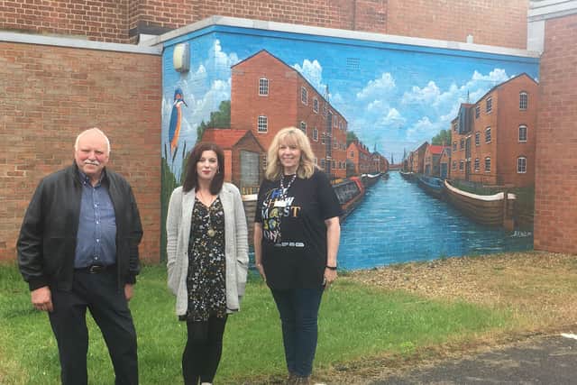 Rob Hall (artist), Sarah Hughes (Lincolnshire One Venues Participation Officer), and Tracey Mackenzie (theatre manager) with the mural