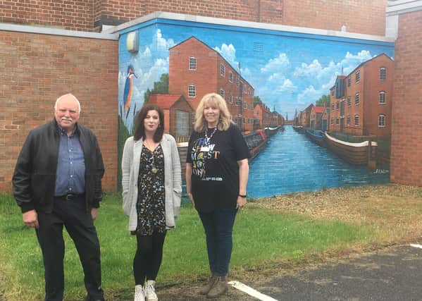 Rob Hall (artist), Sarah Hughes (Lincolnshire One Venues Participation Officer), and Tracey Mackenzie (theatre manager) with the mural