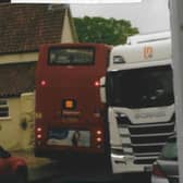 A school bus has to squeeze past a lorry on Leadenham High Street. EMN-210719-190520001