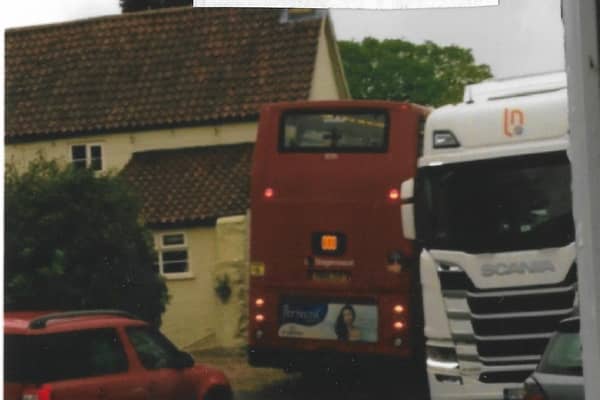 A school bus has to squeeze past a lorry on Leadenham High Street. EMN-210719-190520001