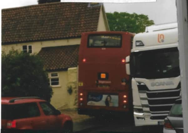 A school bus has to squeeze past a lorry on Leadenham High Street. EMN-210719-190520001