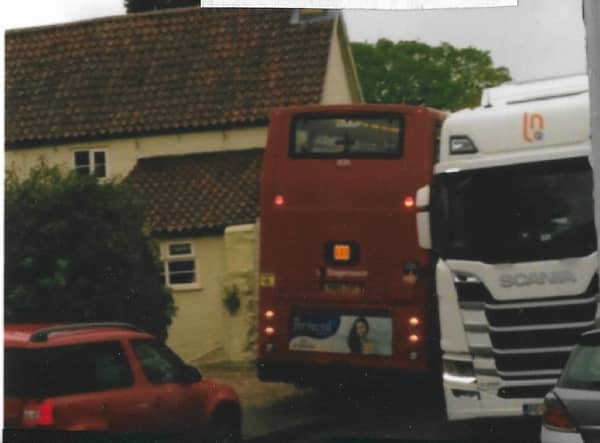 A school bus has to squeeze past a lorry on Leadenham High Street. EMN-210719-190520001