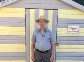 Resident Norman Newton outside one of the beach huts.