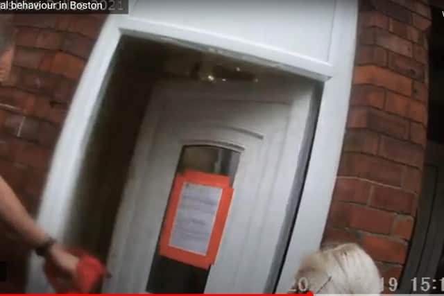 Police officers break down the door of the house in a raid