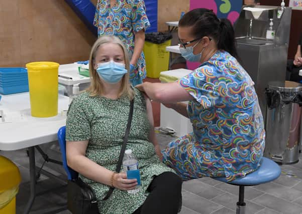 Lisa Szirtes of Sleaford receiving the 1 millionth vaccination in Lincolnshire, at PRSA vaccination centre. The vaccinator is Sam Prichard EMN-210723-142549001