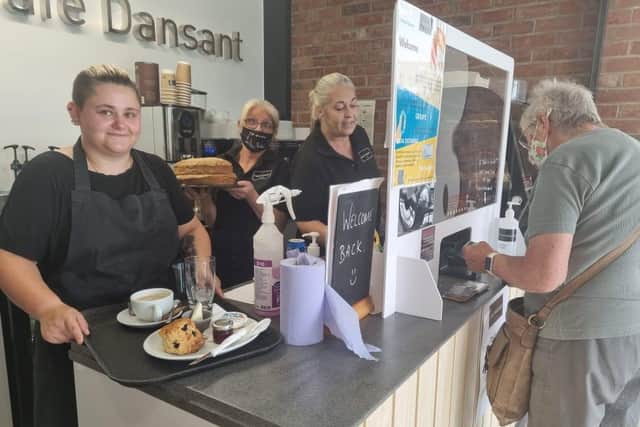 New Cafe Dansant manager Steph Sears (left) with Helena Wainwright at the till and Debbie Jones with one of the homemade cakes.