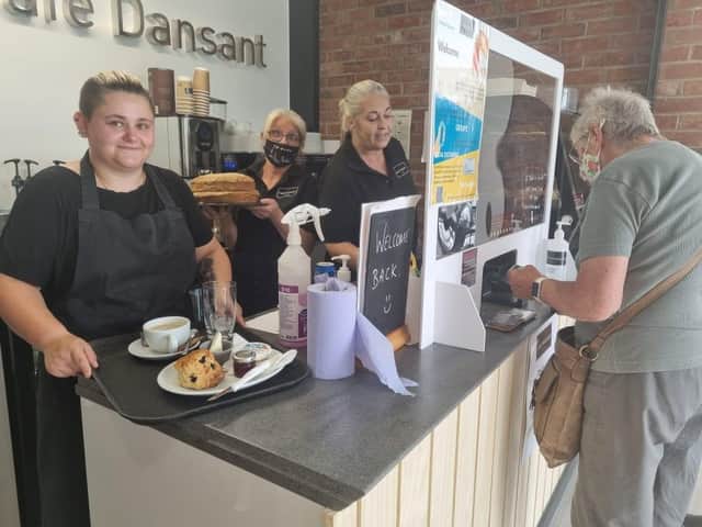 New Cafe Dansant manager Steph Sears (left) with Helena Wainwright at the till and Debbie Jones with one of the homemade cakes.