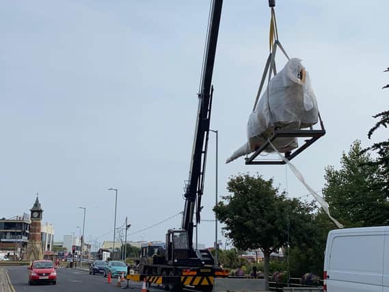 W-raptor - a headless dinosaur in bubble wrap is lifted by crane into a new attraction in Skegness at the former Model Village site.