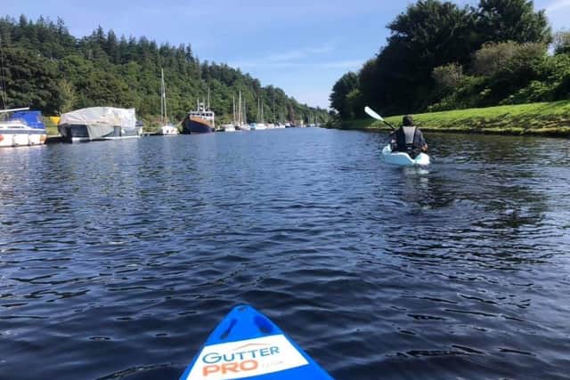 Paddling along the canal on the cross country Scottish challenge. EMN-210830-192959001