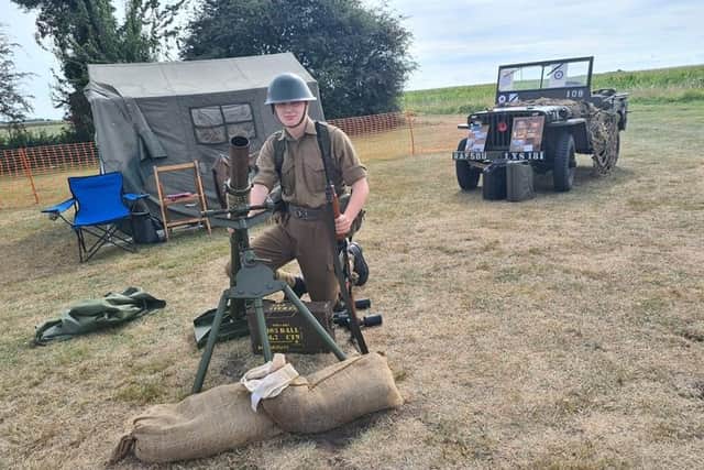 One of the wartime re-enactors with mortar and Jeep. EMN-210916-115540001