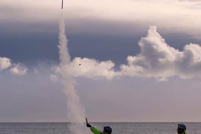 A flare is sent up on the beach.