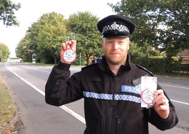 Neighbourhood Policing Sergant Stuart Mumby-Croft, covering Sleaford and its surrounding rural areas, displaying some of the new campaign air fresheners reminding motorists to "Belt up. Hang up. Ease up." EMN-210929-150338001