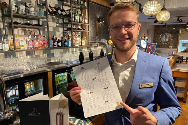 General manager at the White Hart Hotel Dominic Solesbury with a menu and its offer of ‘Invisible Chips’.