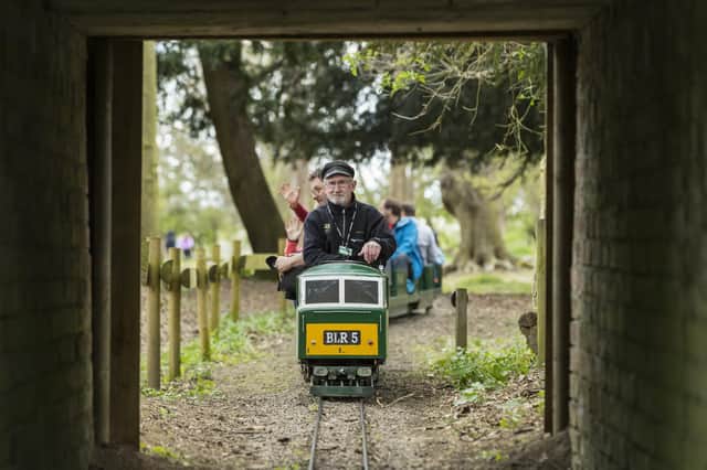 Visitors enjoying a ride on the miniature railway at Belton House, Lincolnshire