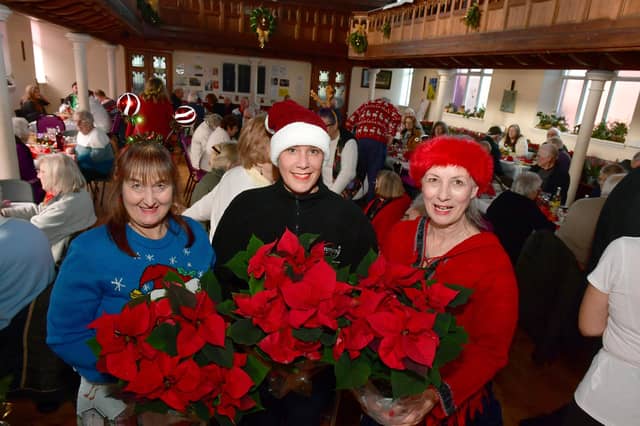 Volunteers with Poinsettias donated by Bells Nurseries (from left) Sarah MacDonald, Leah Donovan and Deborah Bartholomew