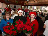Volunteers with Poinsettias donated by Bells Nurseries (from left) Sarah MacDonald, Leah Donovan and  Deborah Bartholomew